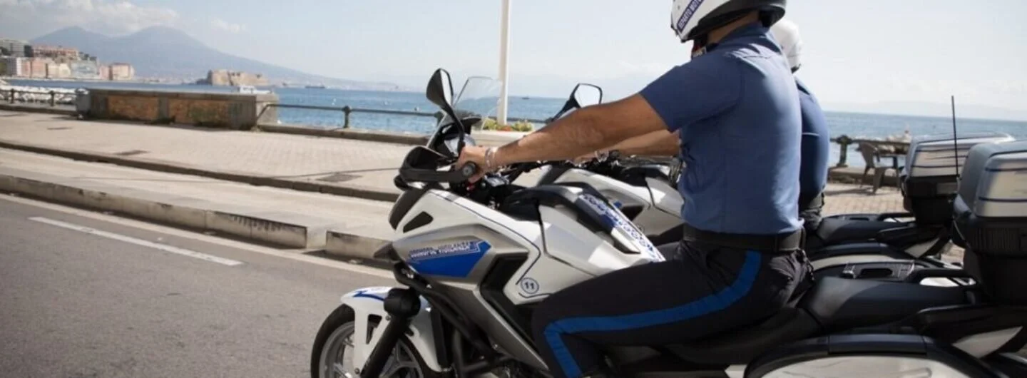 Due guardie giurate in sella alle moto di servizio Cosmopol durante un pattugliamento lungo la costa.