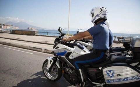 Due guardie giurate in sella alle moto di servizio Cosmopol durante un pattugliamento lungo la costa.